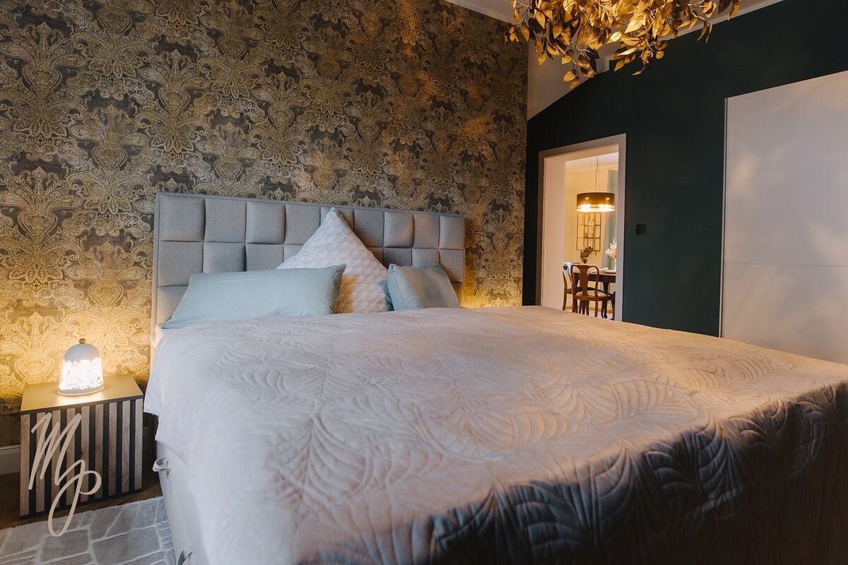 Schlafzimmer mit edler Ornament-Tapete und dunkelgrüner Wand, Tapezierarbeiten SGG