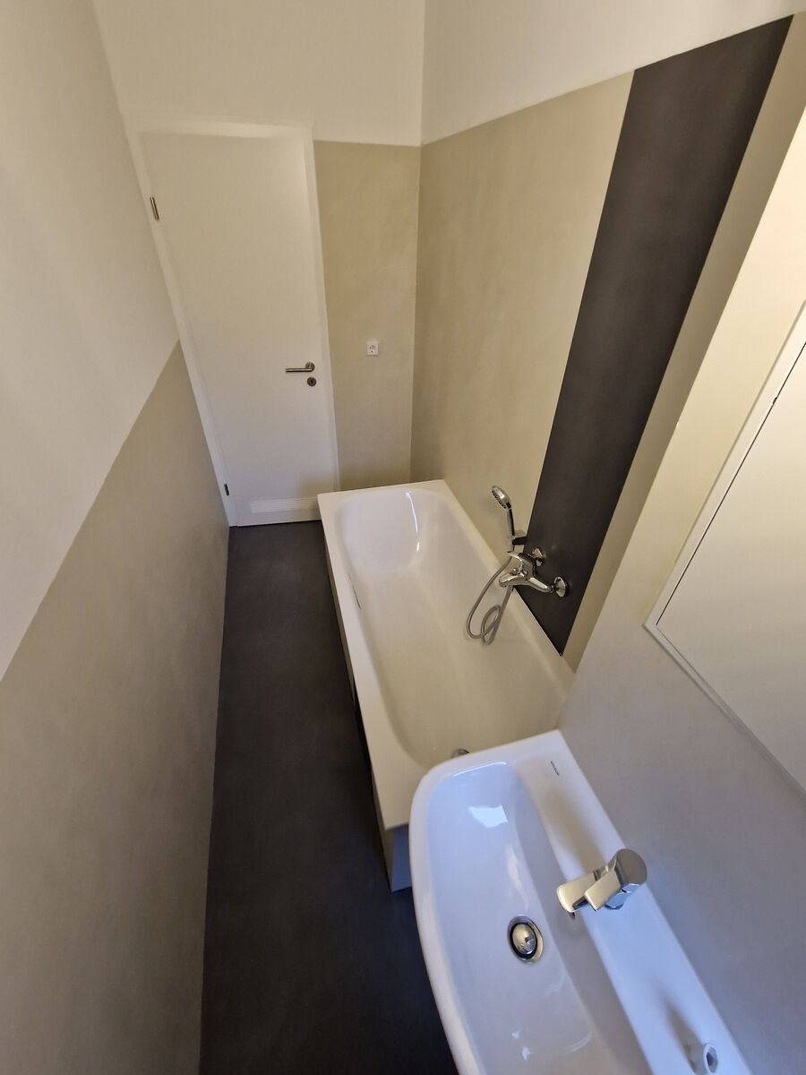 Saniertes Badezimmer mit fugenloser Spachteltechnik an Wand und Boden