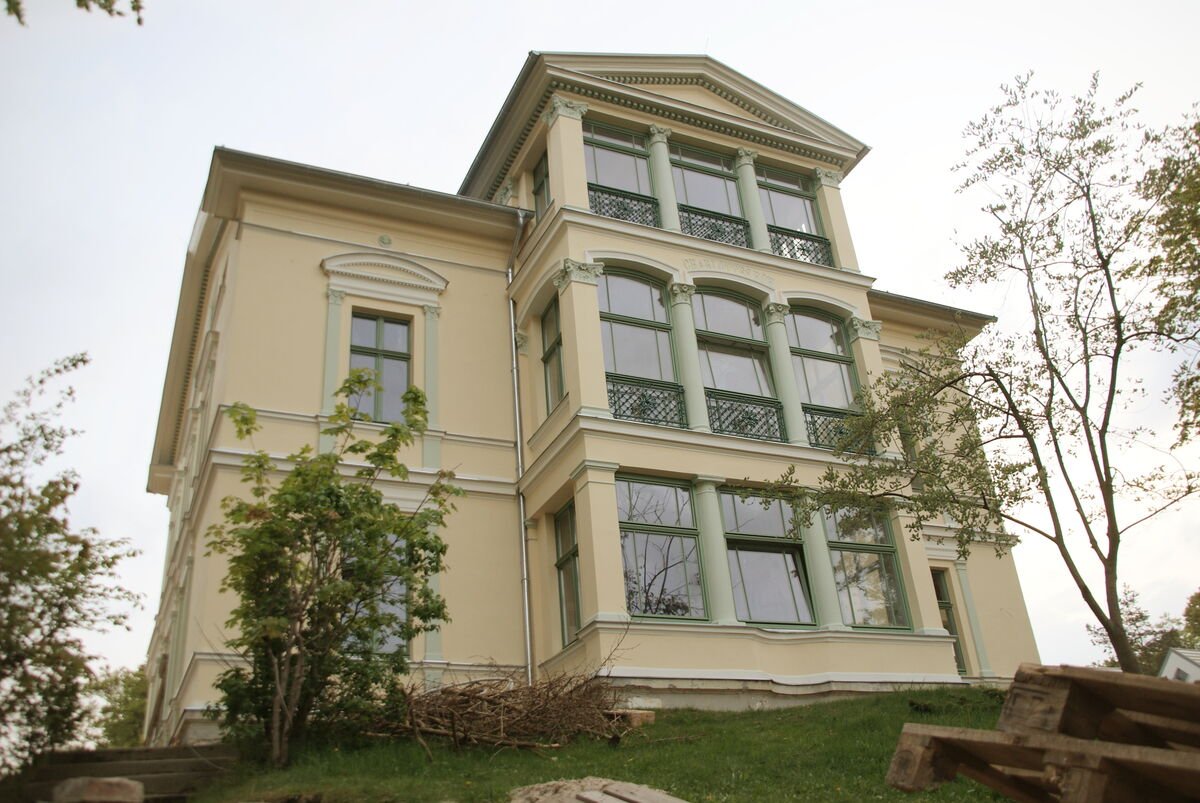 Sanierte Fassade einer historischen Villa mit restaurierten Stuckelementen und grünen Fenstern, Fassadenarbeiten Sachsen-Anhalt