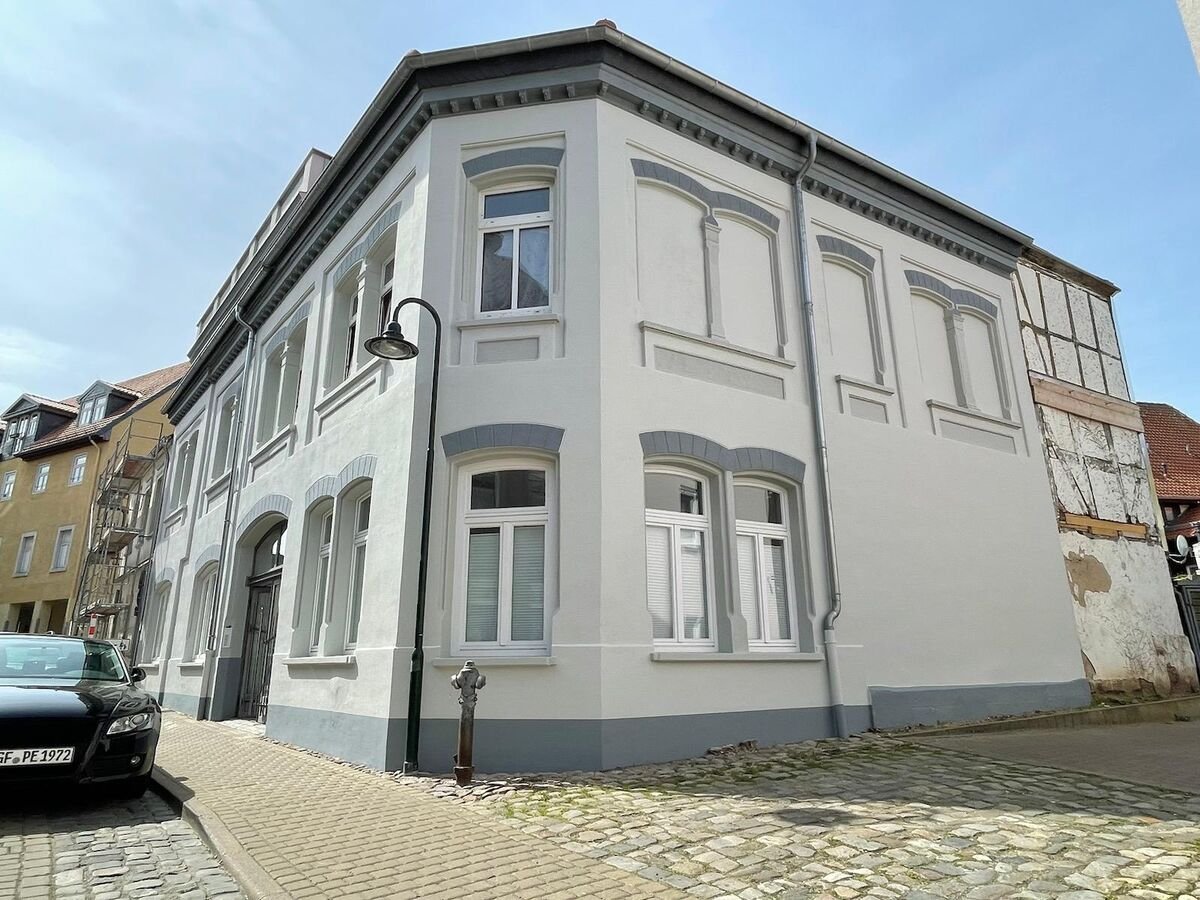 Frisch sanierte Fassade eines Altbau-Eckhauses in Weiß und Grau, Fassadenanstrich Region Magdeburg