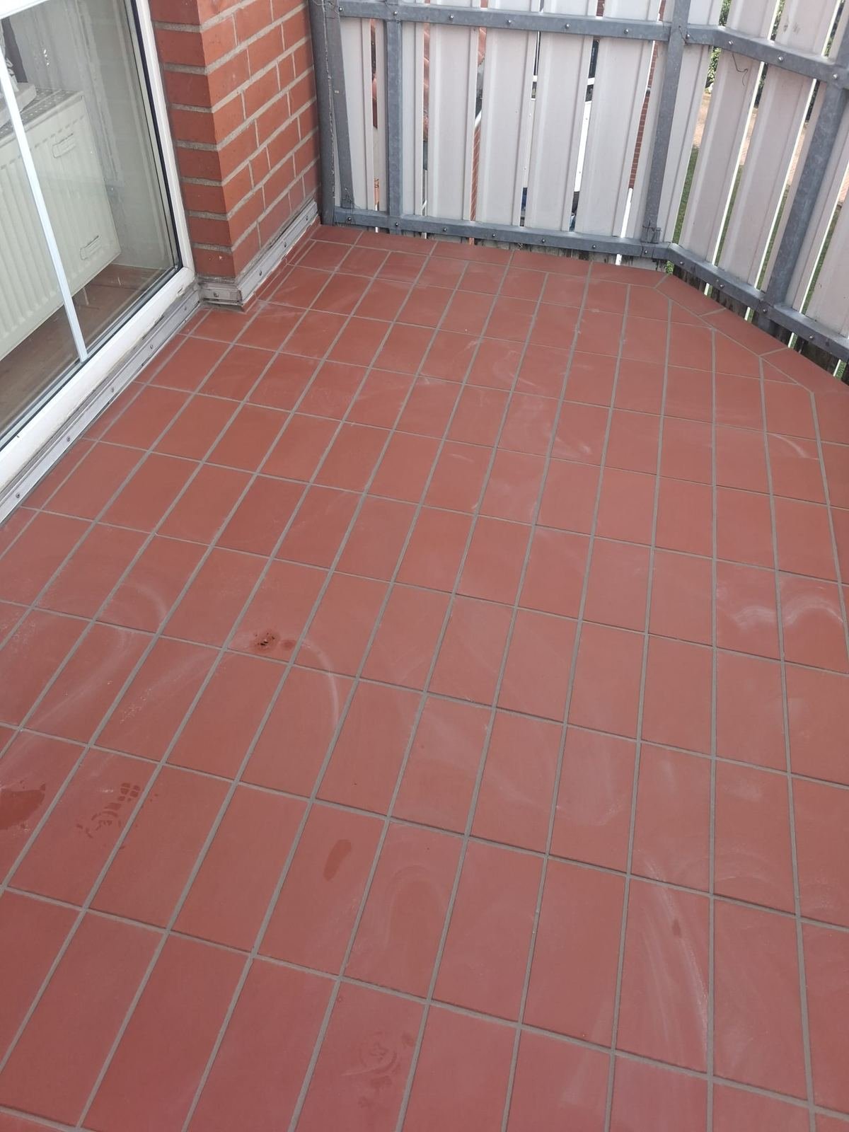 Balkon in Glindenberg mit neuem Fliesenbelag in Terrakotta-Rot und Metallgeländer