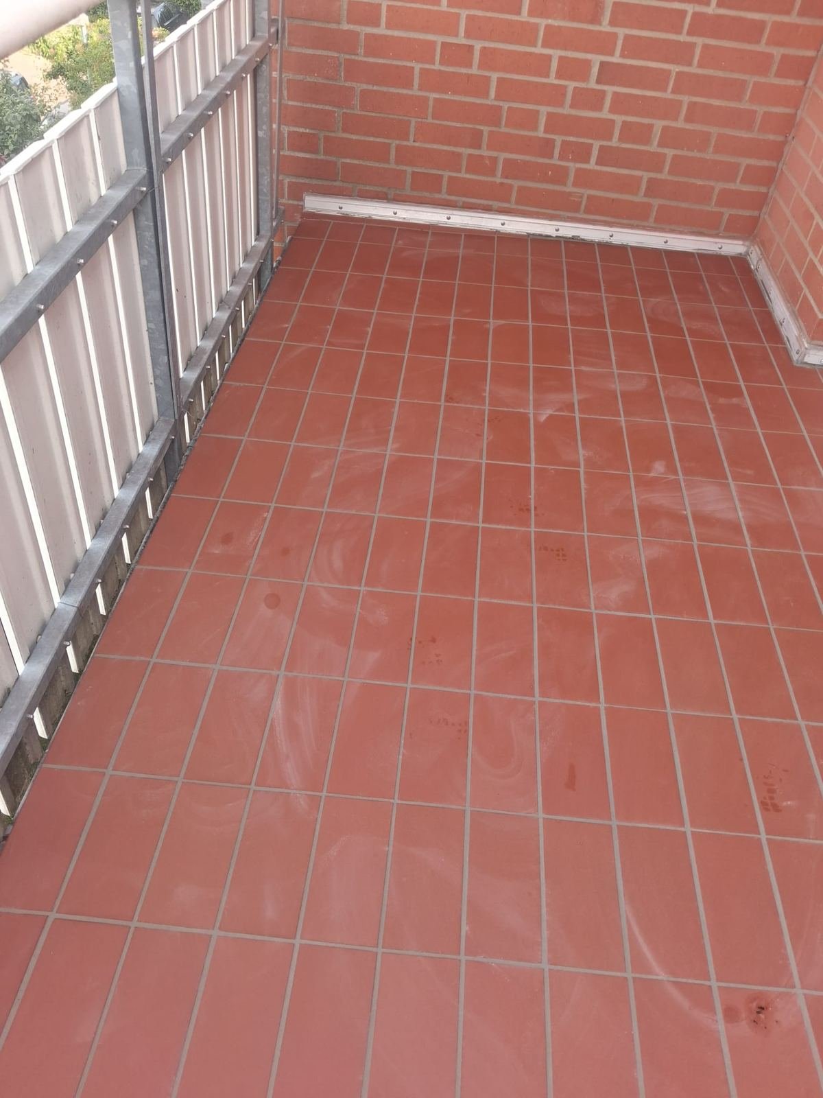 Neu gefliester Balkonboden mit Profilleiste an der Klinkerwand in Glindenberg