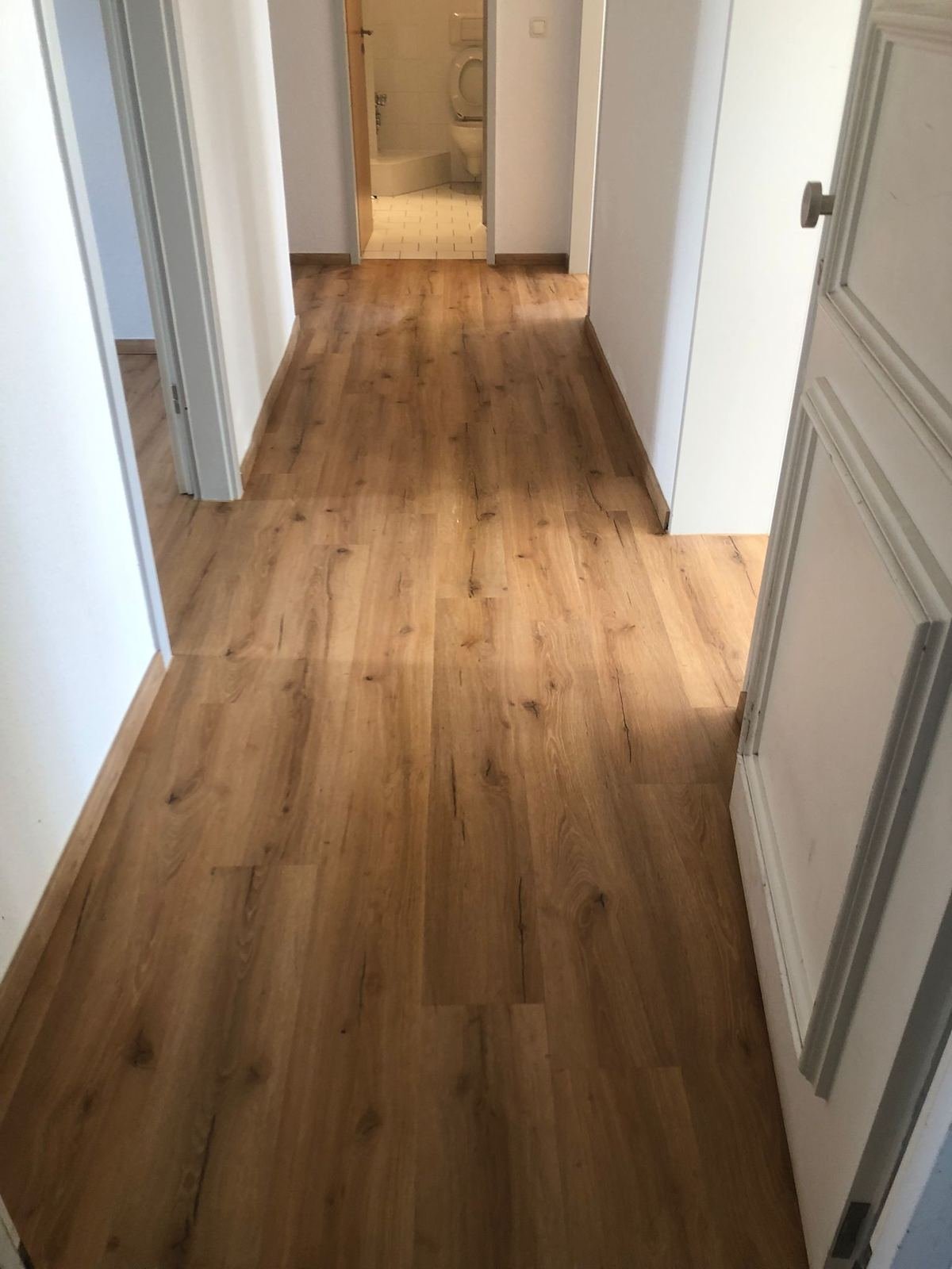 Flur einer Altbauwohnung in Magdeburg mit durchgehendem Boden in Holzoptik